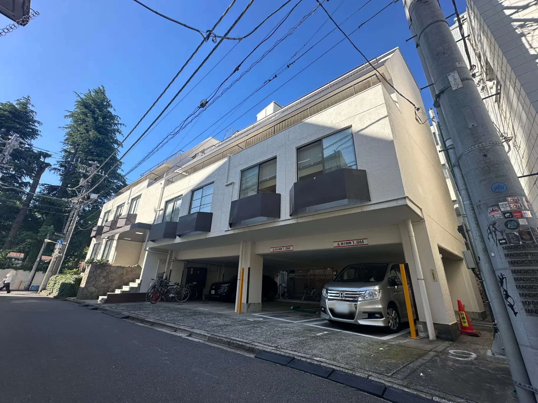 現代的な外観のマンション、駐車スペース付き、晴れた日の都市住宅街