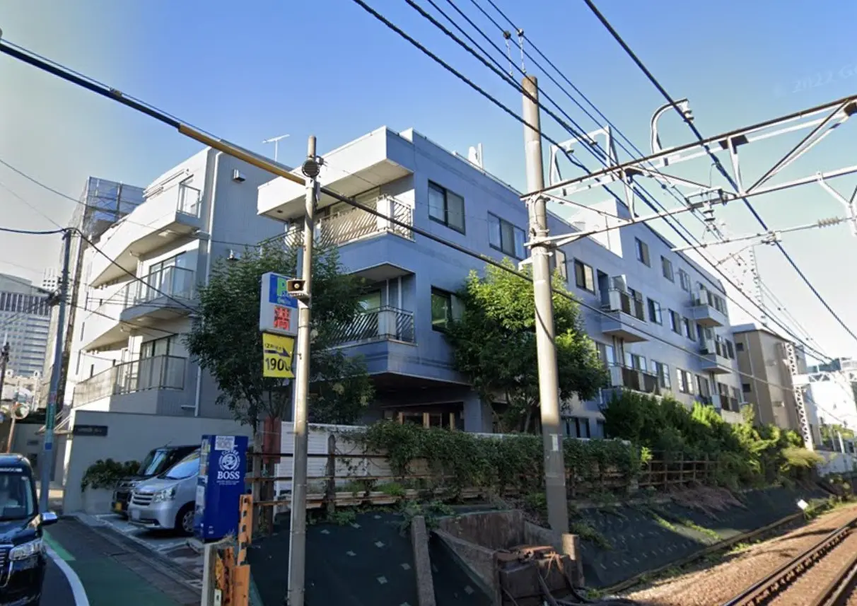 鉄道沿いの現代的な住宅街、複数のバルコニー付きのアパート建物、晴れた日の都市風景