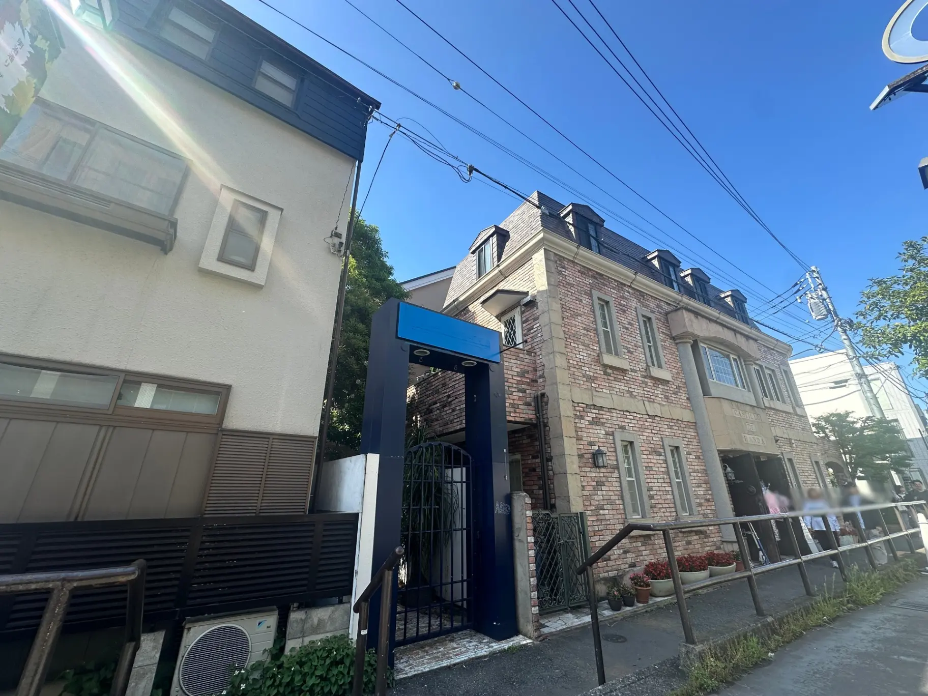 都市の青空の下、レンガ造りの外観が特徴的なモダンなアパートビルの入り口