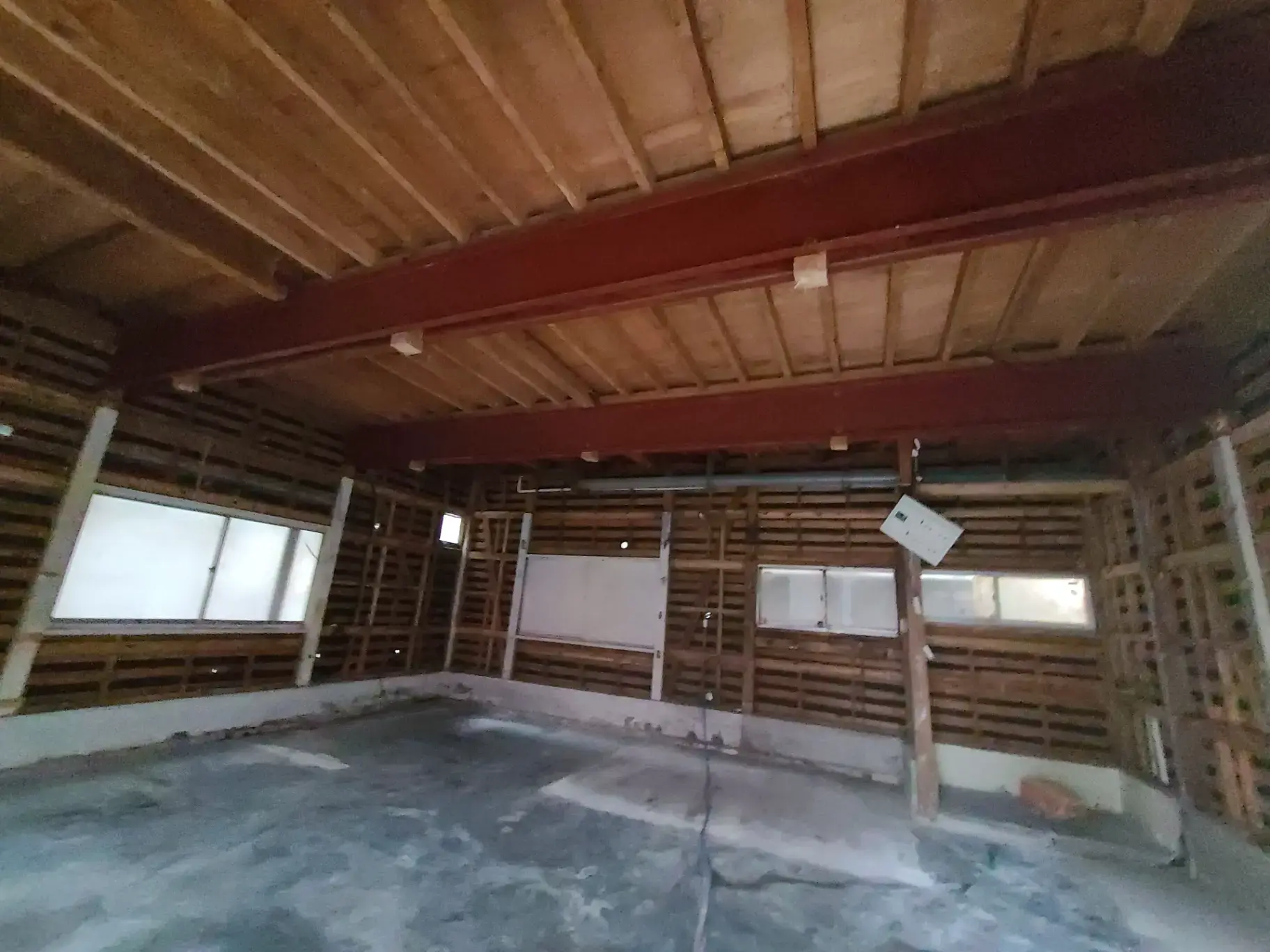 この画像のAlt属性を以下のように設定することを提案します。
"工事中の内部空間、露出した木の梁と窓が見えるリノベーション前の建物の一部"
この代替テキストは、画像の主要な要素を説明しており、リノベーションや建築に関心のあるユーザーに向けてSEOを考慮しています。これによって、検索エンジンがコンテンツを適切にインデックス付けしやすくなります。