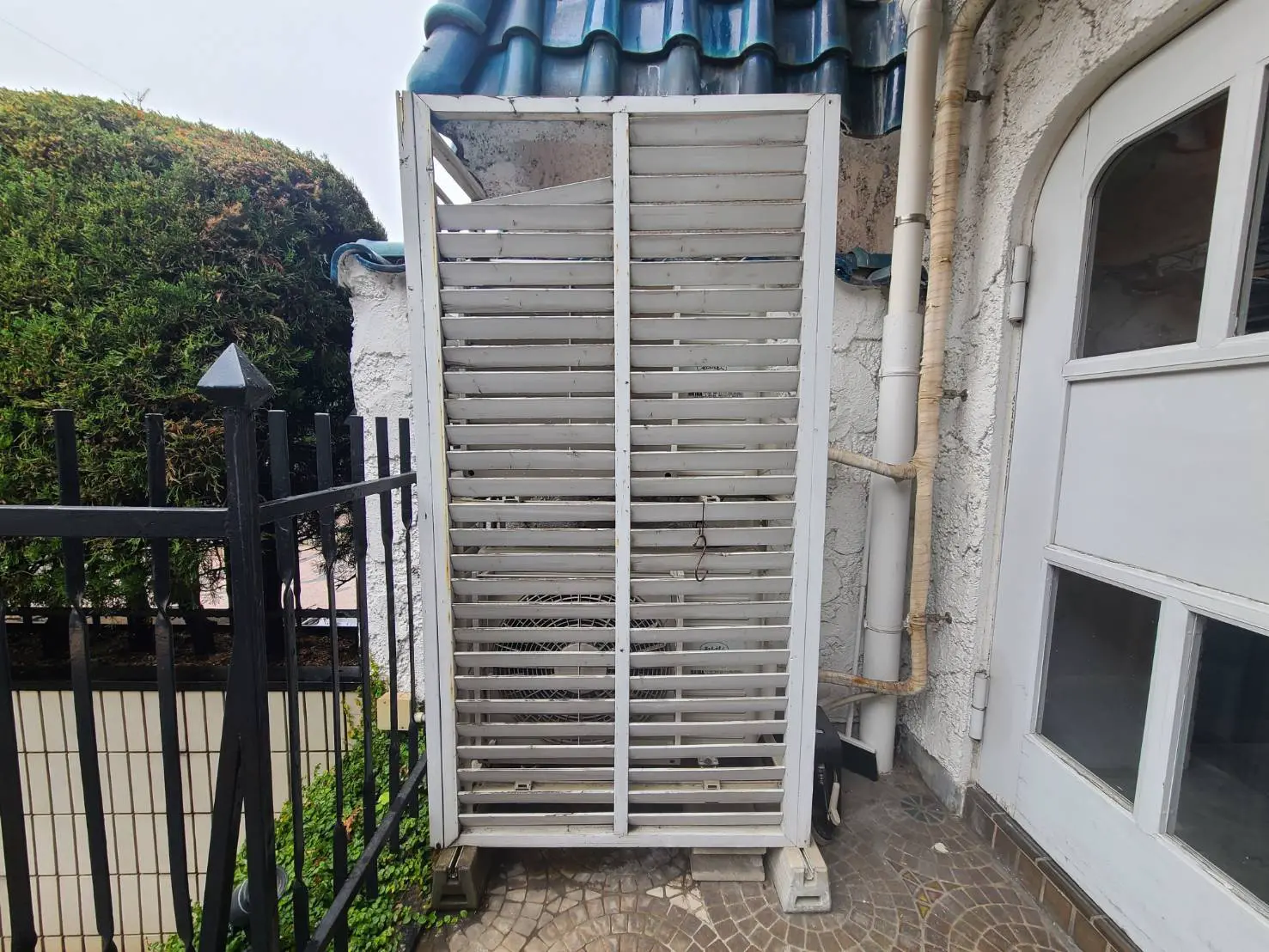 通りからの視線を遮る白いスラットフェンスが設置された物件の入口