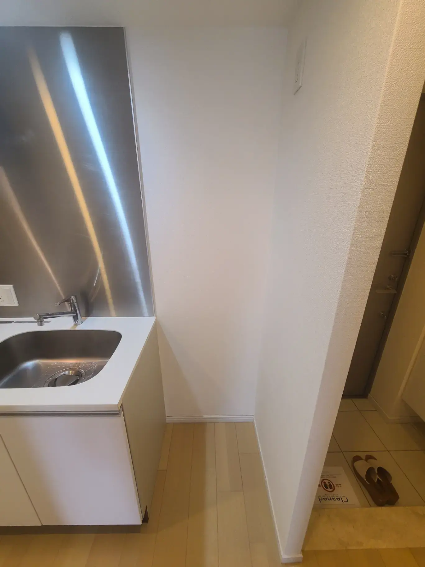 コンパクトなシングルシンクのキッチンスペース、シューズボックス付きの狭いエントランス