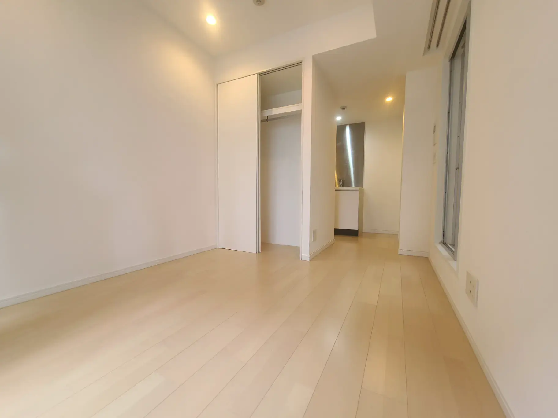 明るく清潔感のあるシンプルなデザインの居室、ナチュラルカラーのフローリング