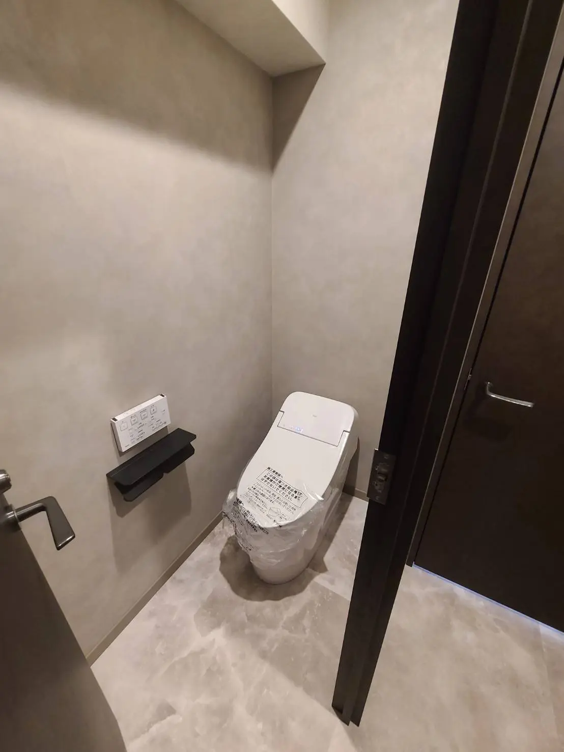 モダンなデザインのトイレとウォシュレットが装備された清潔なバスルーム