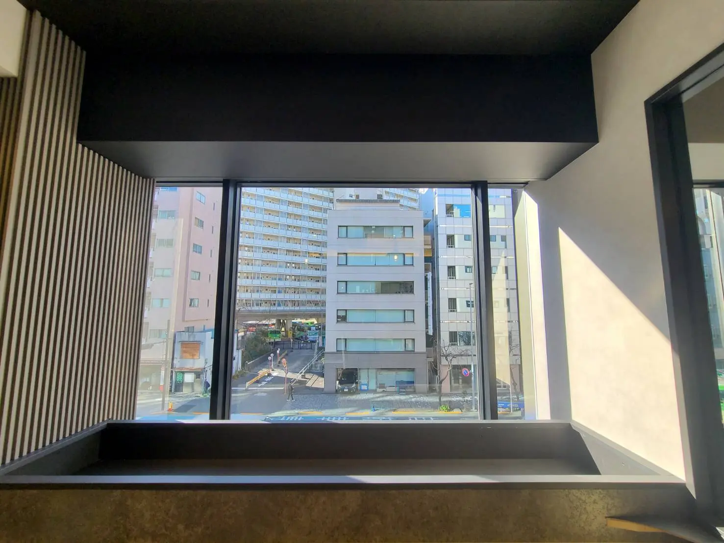 現代的な建築の室内から見た街並み、大きな窓から差し込む自然光、クリアな視界