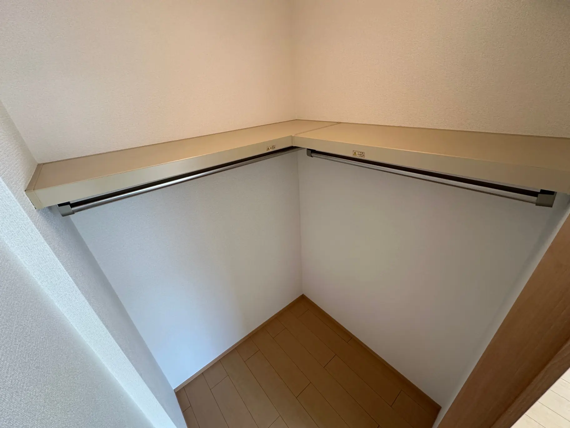 コンパクトな家庭用クローゼット、シンプルなデザインの収納スペース、白い壁と木製のフローリング