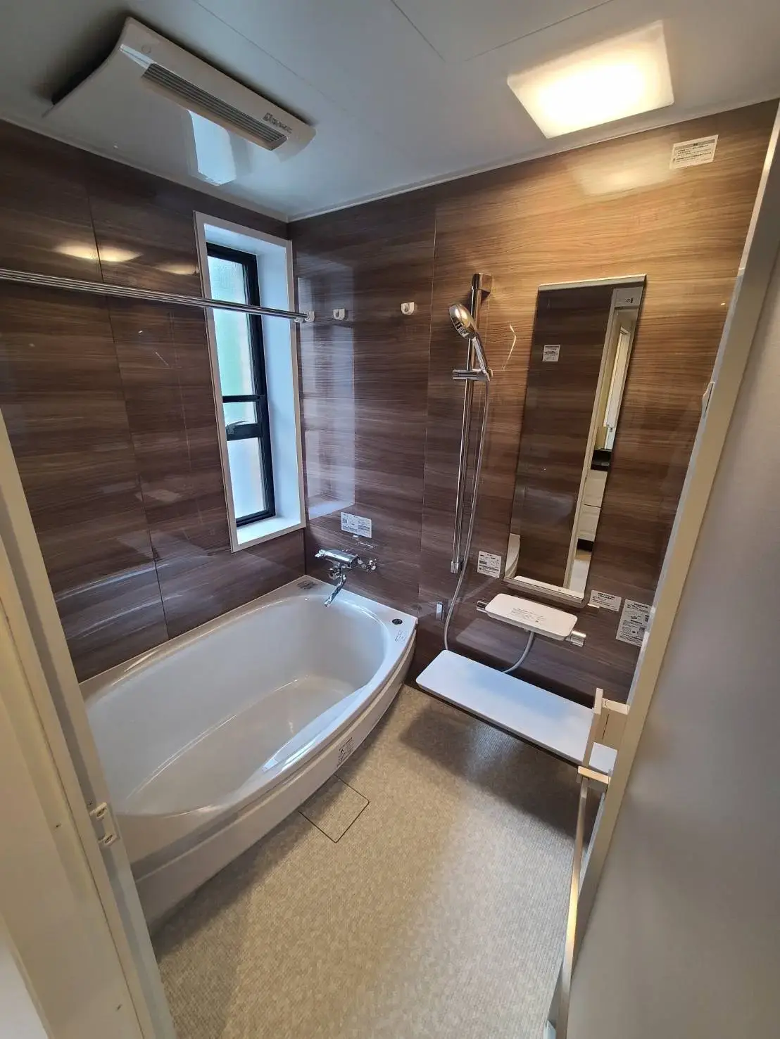 木目調の壁が印象的なバスルーム、独立したシャワースペース付き