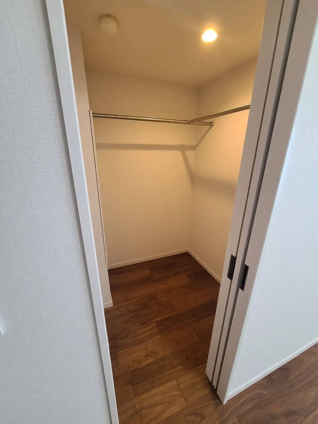 シンプルなデザインの空のクローゼット、木製のフローリングと内蔵型照明