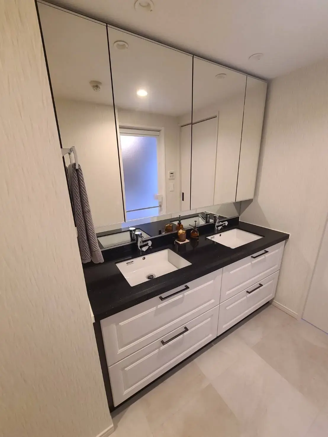 モダンなデザインのダブルシンクバスルーム、大きな鏡と収納キャビネット付き