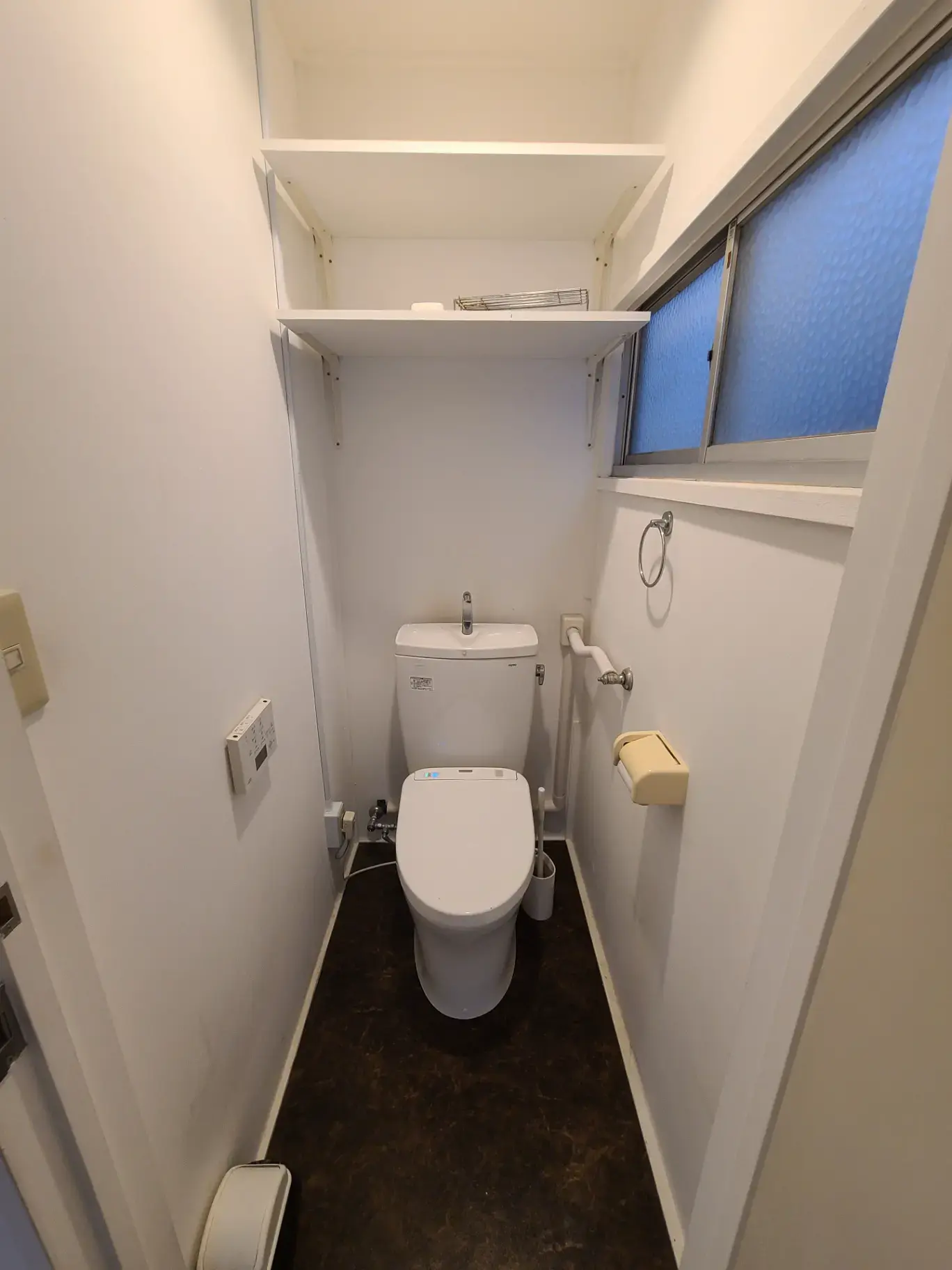 「日本の狭いトイレの内装と配置、便器と洗面所、プライバシーガラスの窓付き」